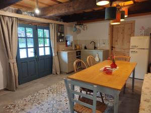 a kitchen with a wooden table and a blue door at Štalca in Bušinja Vas
