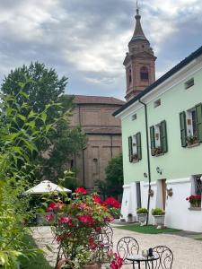 a building with a clock tower and a table and chairs at B&B Il Castello di Alberico in Cotignola