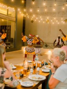 a group of people sitting at a table watching a performance at Sandy Bliss Mirissa in Mirissa