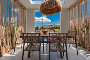 a dining room with a table with chairs and an umbrella at Kassandra Villas in Hanioti
