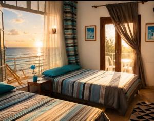 two beds in a bedroom with a view of the ocean at Santiago Apartment Mallorca in Cala Figuera +19 photos