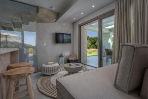 a living room with a couch and a tv at Kassandra Villas in Hanioti
