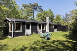 a small black house with a table in the yard at 13318-Asnaes-Lindevej-10 in Asnæs