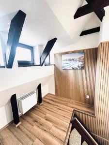a living room with a tv and a wooden floor at Apartmány Haberschie in Řehlovice