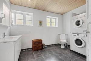 a bathroom with a washing machine and a toilet at 0163-Romo-Havnebyvej-5 in Høm