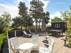 a patio with a table and chairs and an umbrella at 0163-Romo-Havnebyvej-5 in Høm +16 photos