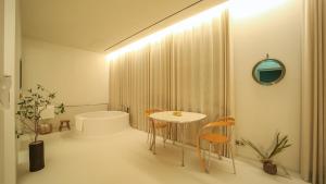 a bathroom with a table and chairs and a tub at Ripple Boutique Hotel in Yangpyeong +43 photos
