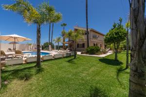 a yard with a pool and chairs and a house at Villa Agueda in Muro