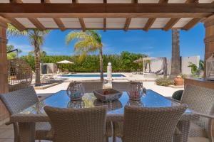 a patio with a table and chairs and a pool at Villa Agueda in Muro