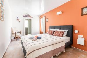 a bedroom with a large bed with an orange wall at Casa S’Arraval in Mahón