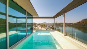 a swimming pool in a house with a view of the water at Ripple Boutique Hotel in Yangpyeong