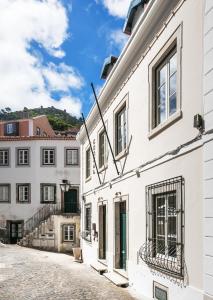 a white building with windows on a street at Pendoa Sintra Collection-Soft Opening in Sintra