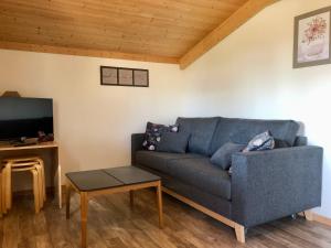 a living room with a blue couch and a table at Camping Pré-Fixe in Cassagnabère-Tournas