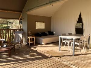 a room with a bed and a table and chairs at Camping Pré-Fixe in Cassagnabère-Tournas
