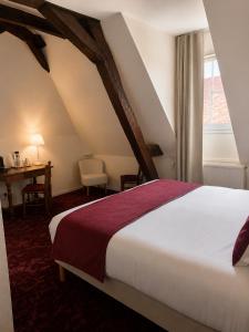a bedroom with a bed and a desk and a window at Teritoria Hôtel Wilson in Dijon +73 photos