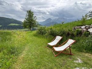 two chairs sitting on top of a grassy hill at Hörndlhof in Abtenau