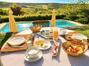 a table with food on it next to a pool at Clos de Fougères - La Grange 6-7 personnes in Montoillot