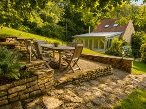 a patio with a table and chairs in a yard at Clos de Fougères - La Grange 6-7 personnes in Montoillot