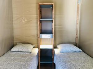 two beds in a small room with two beds at Camping Pré-Fixe in Cassagnabère-Tournas +41 photos