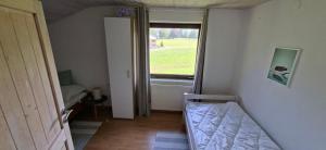 a small bedroom with a bed and a window at Ferienwohnung Meusburger in Hittisau