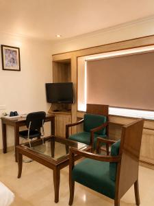 a room with chairs and a table and a screen at May Fair in Mandi +11 photos