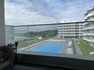 a balcony with a swimming pool and a large building at LUX Apartament Rogowo Pearl in Rogowo