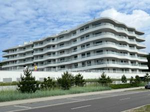 a large white building on the side of a road at LUX Apartament Rogowo Pearl in Rogowo