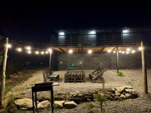 a patio with a picnic table and lights at night at Uno Cottage Kazbegi in Kazbegi