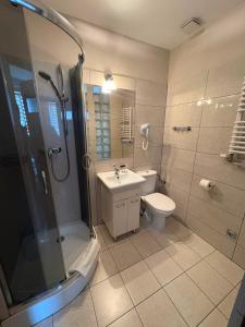 a bathroom with a shower and a toilet and a sink at Hotel Polonia in Ostrów Wielkopolski +57 photos