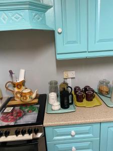 a kitchen counter with blue cabinets and a stove top at The Barn Lodge in Derryounce