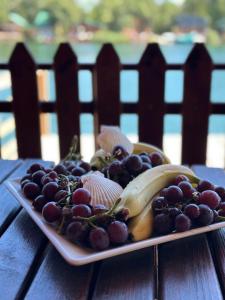 a plate of grapes and bananas on a table at Ada Bojana Kucica in Ulcinj +6 photos