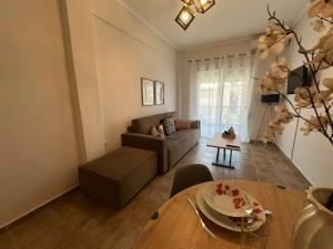 a living room with a couch and a table at Otium Apartment in Nea Peramos