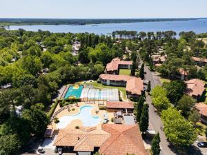 an aerial view of a home with a pool and a resort at Résidence Pierre & Vacances Les Cottages Du Lac in Parentis-en-Born +117 photos