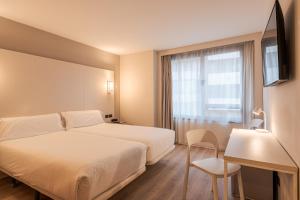 a hotel room with two beds and a window at B&B HOTEL Castellón in Castellón de la Plana