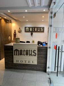 a mens hotel sign on a counter in a building at Hôtel Matous in Tunis
