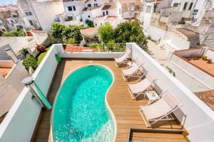 a swimming pool on the roof of a building with chairs at Casa S’Arraval in Mahón