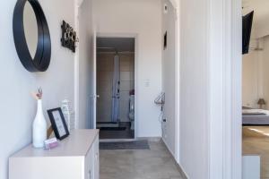a hallway with white walls and a mirror on the wall at Rodostagma 1 in Rodholívos