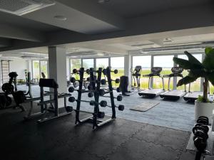 a gym with treadmills and machines in a room at LUX Apartament Rogowo Pearl in Rogowo