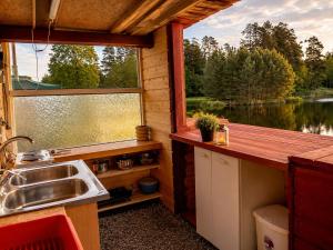 a kitchen with a sink and a large window at Peaceful Nature Cottage near Talsi with Hot Tub, Sauna & Pond, Camping Ives in Talsi +24 photos