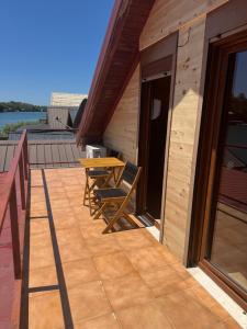 a wooden deck with a wooden table and a bench at Ada Bojana Kucica in Ulcinj