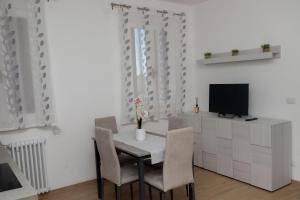 a dining room with a table and chairs and a television at Apollinare's House in Classe