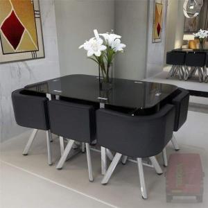 a black dining room table with black chairs and a vase of flowers at ابراج الصفوه الذهبيه 1 in Cairo