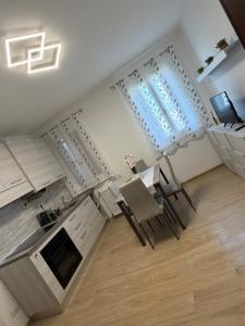 a kitchen with white cabinets and a table and chairs at Apollinare's House in Classe