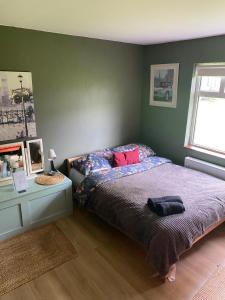 a bedroom with a bed and a table and a window at The Barn Lodge in Derryounce