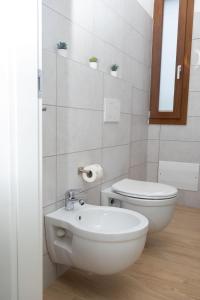 a white bathroom with a toilet and a sink at Apollinare's House in Classe