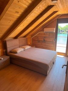 a bed in a room with a wooden ceiling at Ada Bojana Kucica in Ulcinj