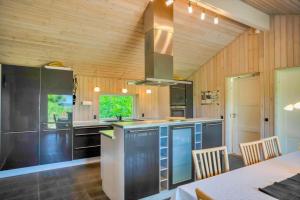 a kitchen with wooden walls and a stove top oven at 11806-Nykobing-Sj-Klintegarden-1 in Klint