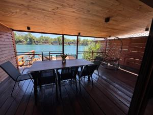 a table and chairs on a deck with a view of the water at Ada Bojana Kucica in Ulcinj