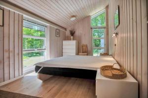 a bedroom with a large bed and two windows at 11806-Nykobing-Sj-Klintegarden-1 in Klint