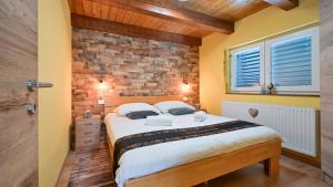 a bedroom with a bed and a brick wall at Villa Exclusive by Villas Guide in Lepoglava +39 photos